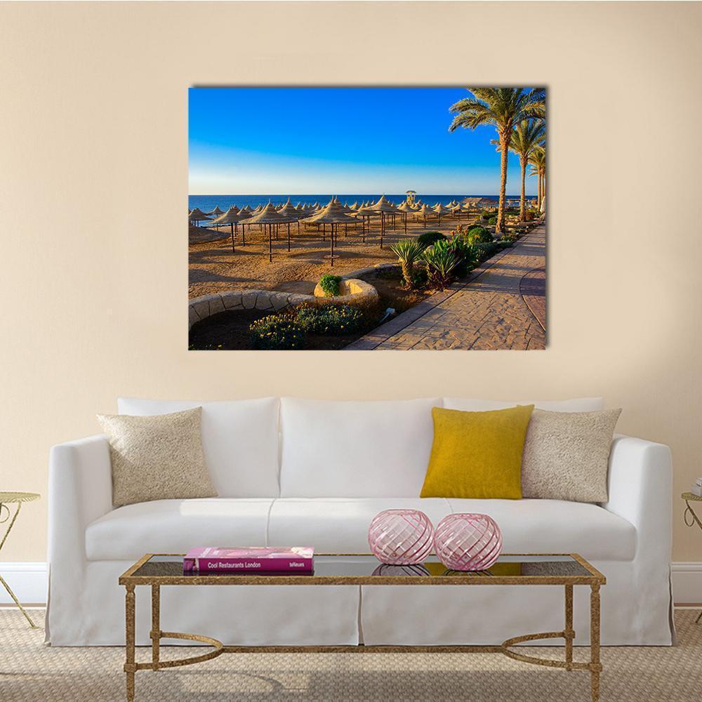 Umbrellas on Sandy Beach Canvas Wall Art in beige, brown and blue, single panel hung on a wall