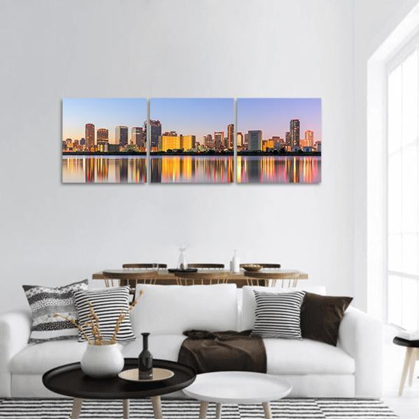 Umeda District Skyline at Dusk Panoramic Canvas Wall Art in orange, yellow and blue, hung on a wall