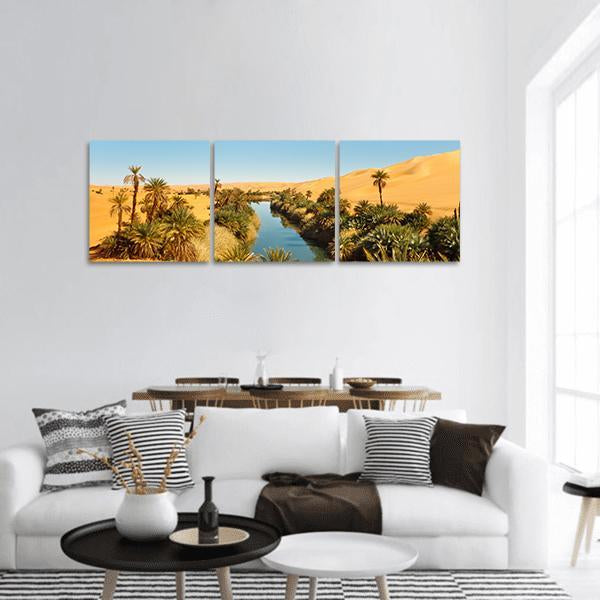 Umm Al-ma Desert Lake Oasis Panoramic Canvas Wall Art in yellow, green and blue, hung on a wall