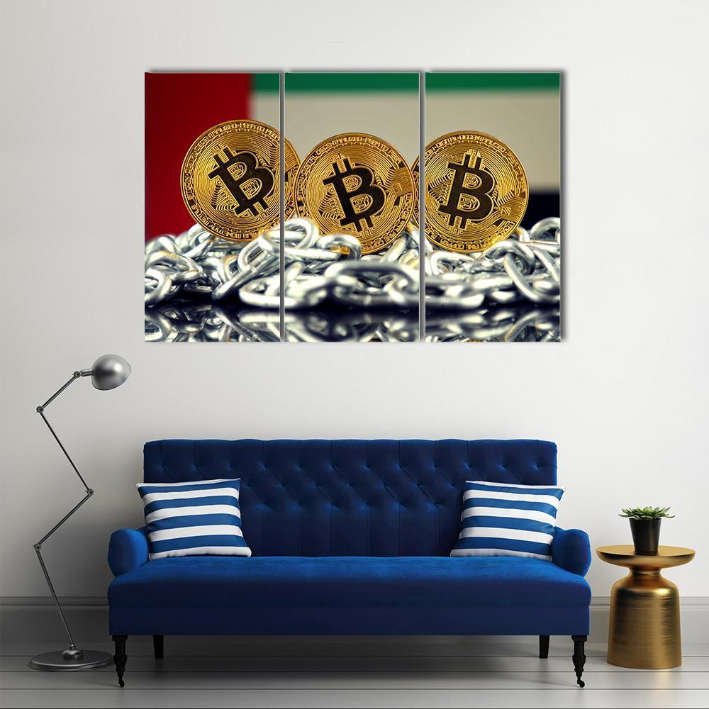 Banned Bitcoin with Uae Flag and Chains Canvas Wall Art in black, gold and silver, 3 panel horizontal set hung on a wall
