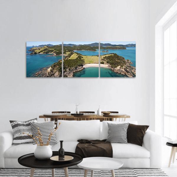 Urupukapuka Island Coastal View Panoramic Canvas Wall Art in green and blue, hung on a wall