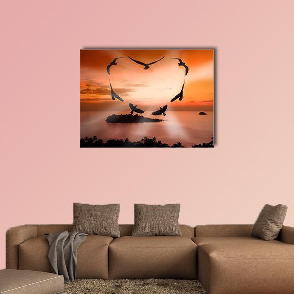 Birds Forming a Heart at Sunset Canvas Wall Art in black, orange and yellow, single panel hung on a wall