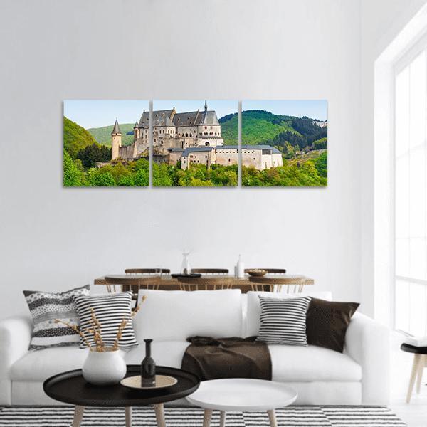 Vianden Castle on Forested Hill Panoramic Canvas Wall Art in gray, green and blue, hung on a wall