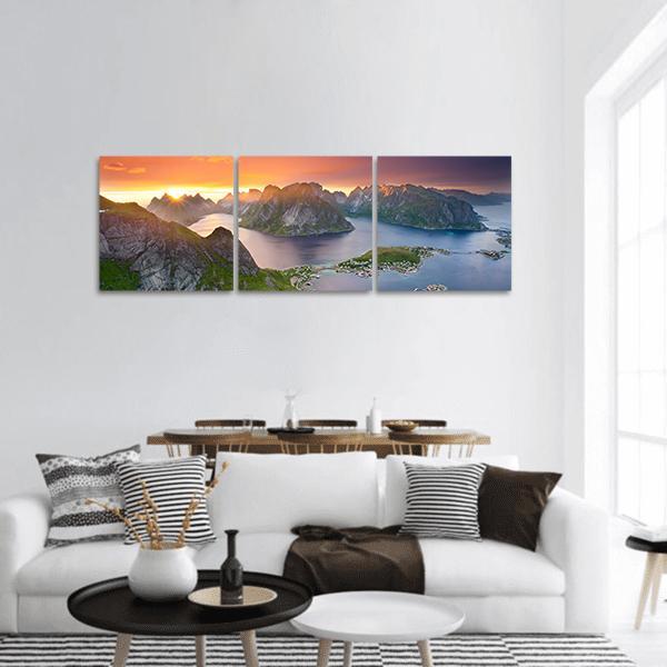 Sunburst Over Coastal Island Village Panoramic Canvas Wall Art in orange, yellow and blue, hung on a wall