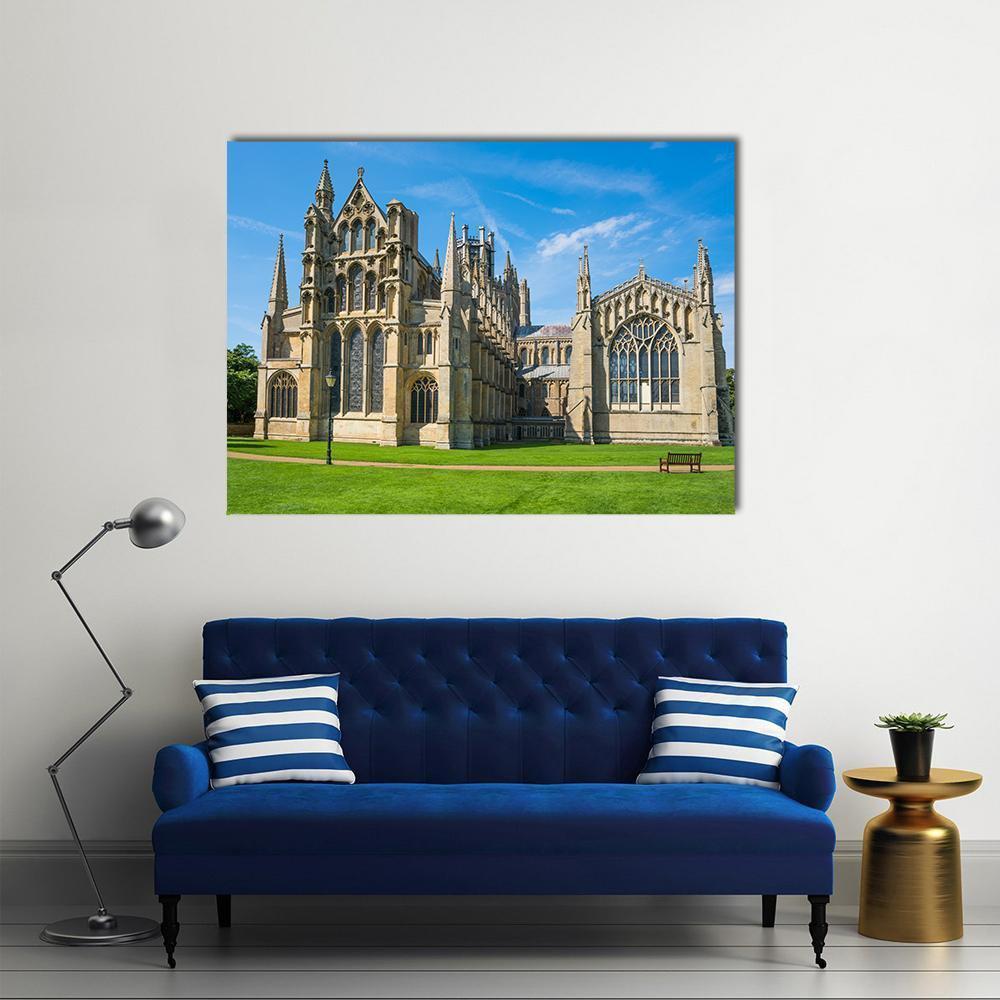 Gothic Cathedral on Sunlit Lawn Canvas Wall Art in beige, green and blue, single panel hung on a wall