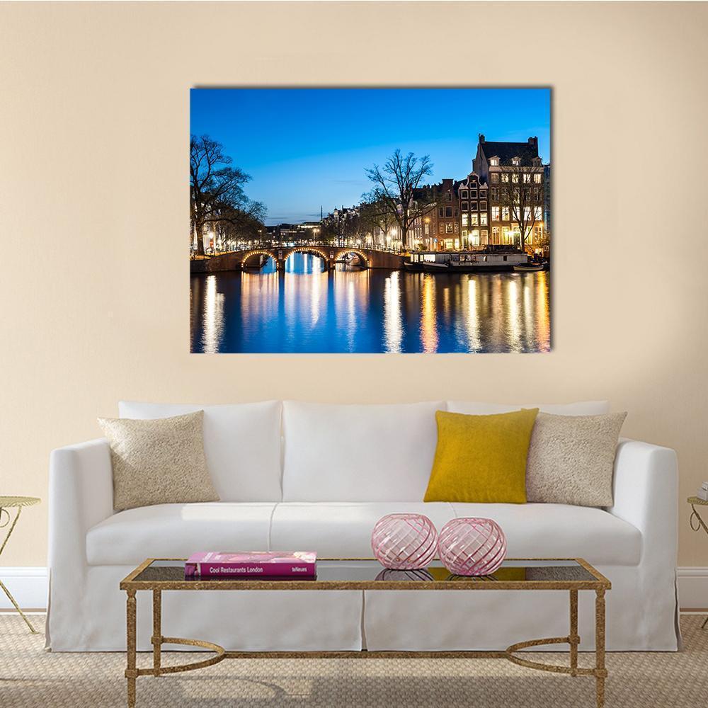 Amsterdam Canal at Night Canvas Wall Art in black, yellow and blue, single panel hung on a wall