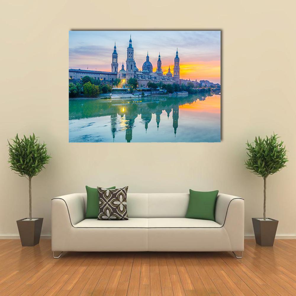 Basilica of Our Lady of the Pillar at Sunset Canvas Wall Art in orange, yellow and blue, single panel hung on a wall