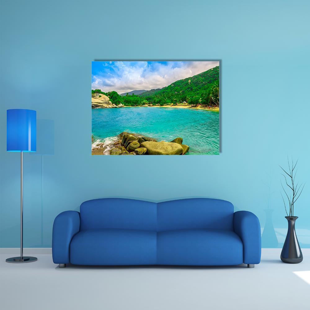 Tropical Beach with Turquoise Water and Boulders Canvas Wall Art in green and blue, single panel hung on a wall