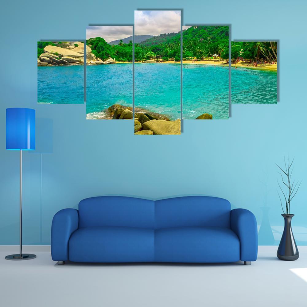 Tropical Beach with Turquoise Water and Boulders Canvas Wall Art in green and blue, 5 panel Star layout hung on a wall