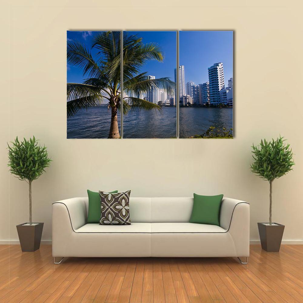 Boca Grande Cartagena Skyline with Palm Canvas Wall Art in white, green and blue, 3 panel horizontal set hung on a wall