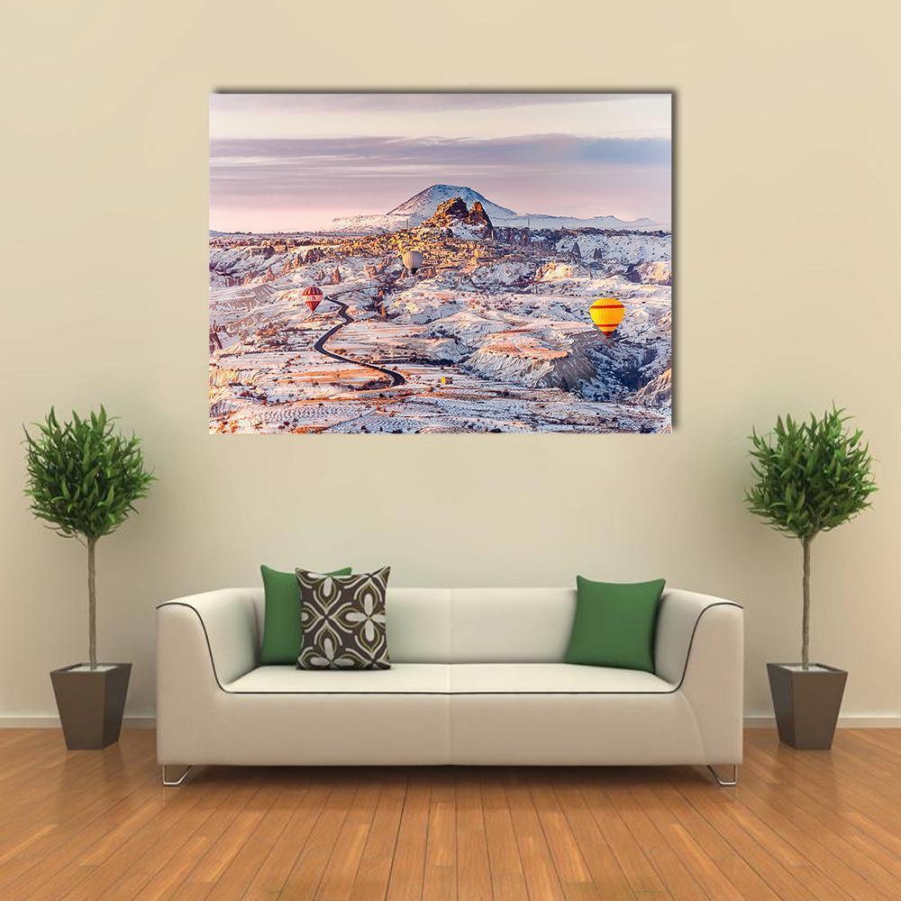 Cappadocia Winter Landscape with Hot Air Balloons Canvas Wall Art in white, gray and pink, single panel hung on a wall