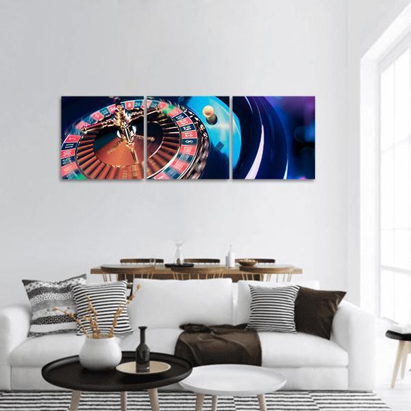 Roulette Wheel in Motion Panoramic Canvas Wall Art in gold, red and blue, hung on a wall