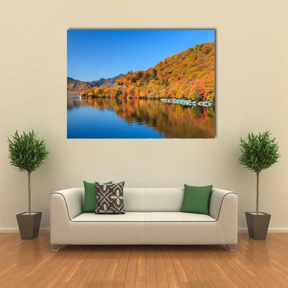 Autumn Lake View with Mountains and Boats Canvas Wall Art in orange, yellow and blue, single panel hung on a wall