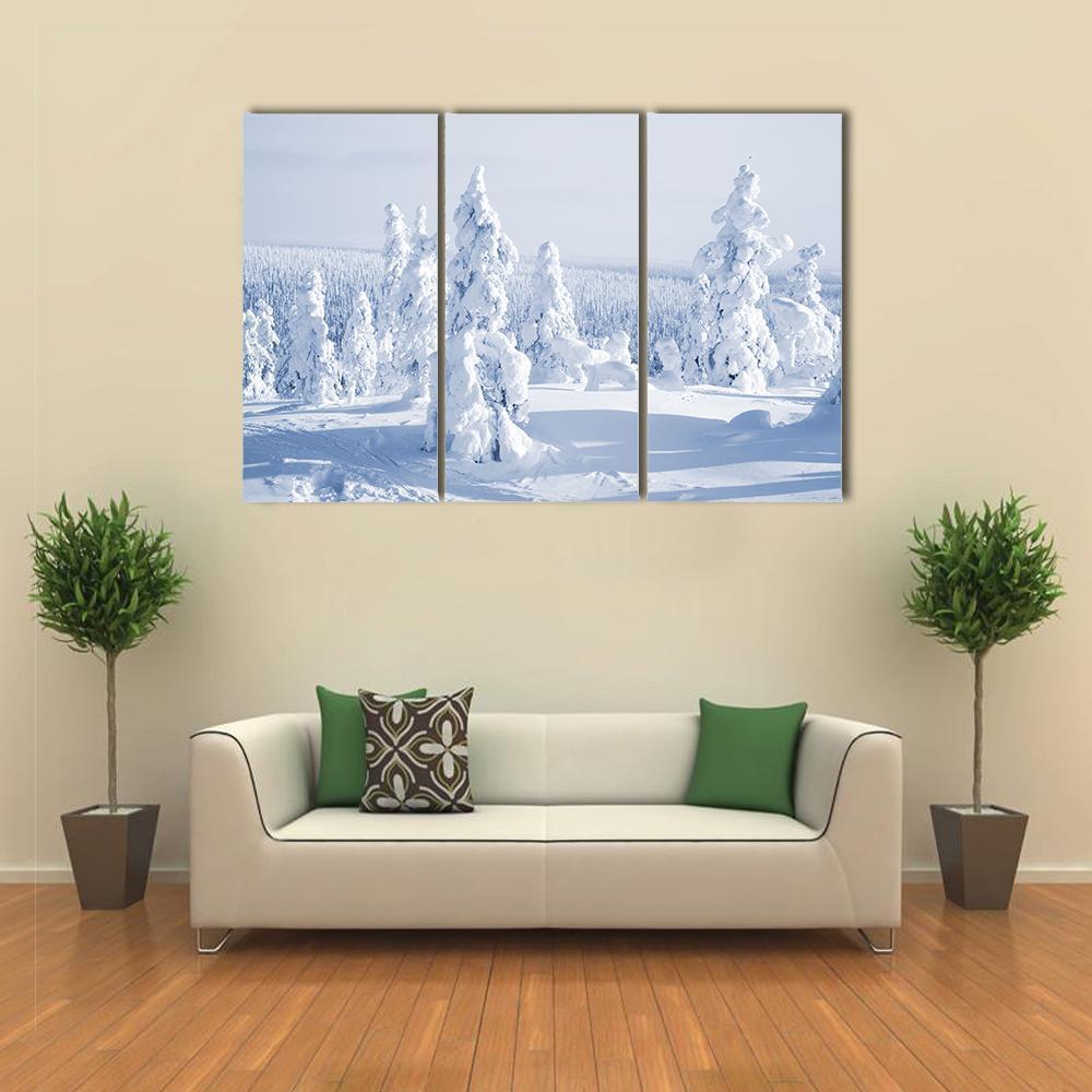 Serene Winter Landscape with Snowy Trees Canvas Wall Art in white, gray and blue, 3 panel horizontal set hung on a wall