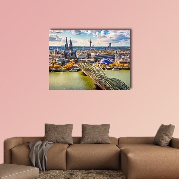 Riverside Cityscape with Cathedral Towers Canvas Wall Art in yellow, green and blue, single panel hung on a wall
