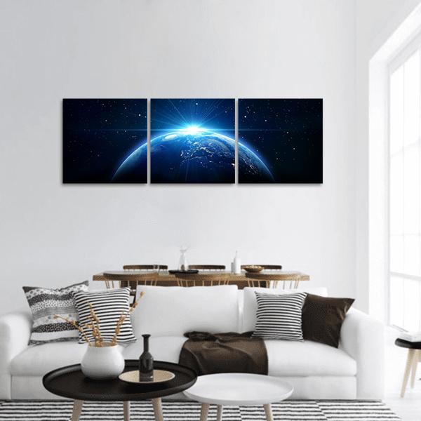 Orbital Sunrise Over Earth Panoramic Canvas Wall Art in black and blue, hung on a wall