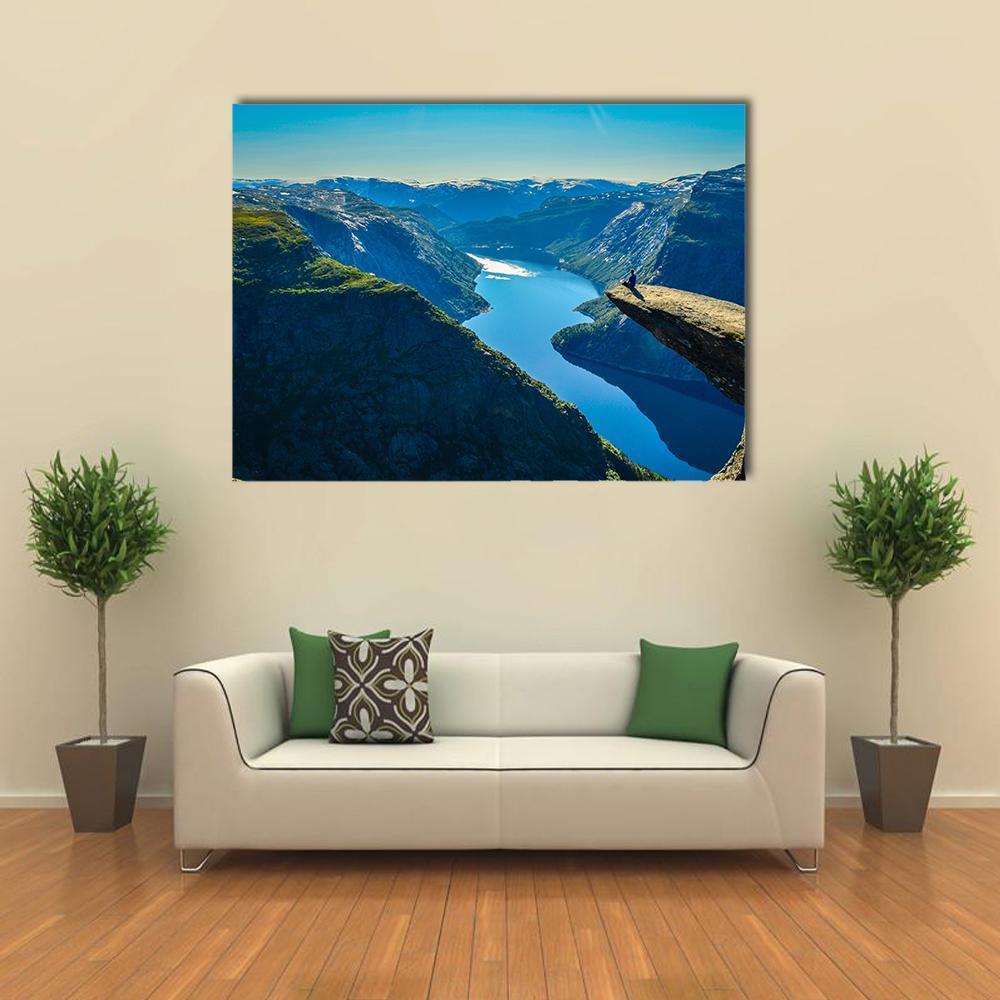 Person on Cliff Over Fjord Canvas Wall Art in gray, green and blue, single panel hung on a wall
