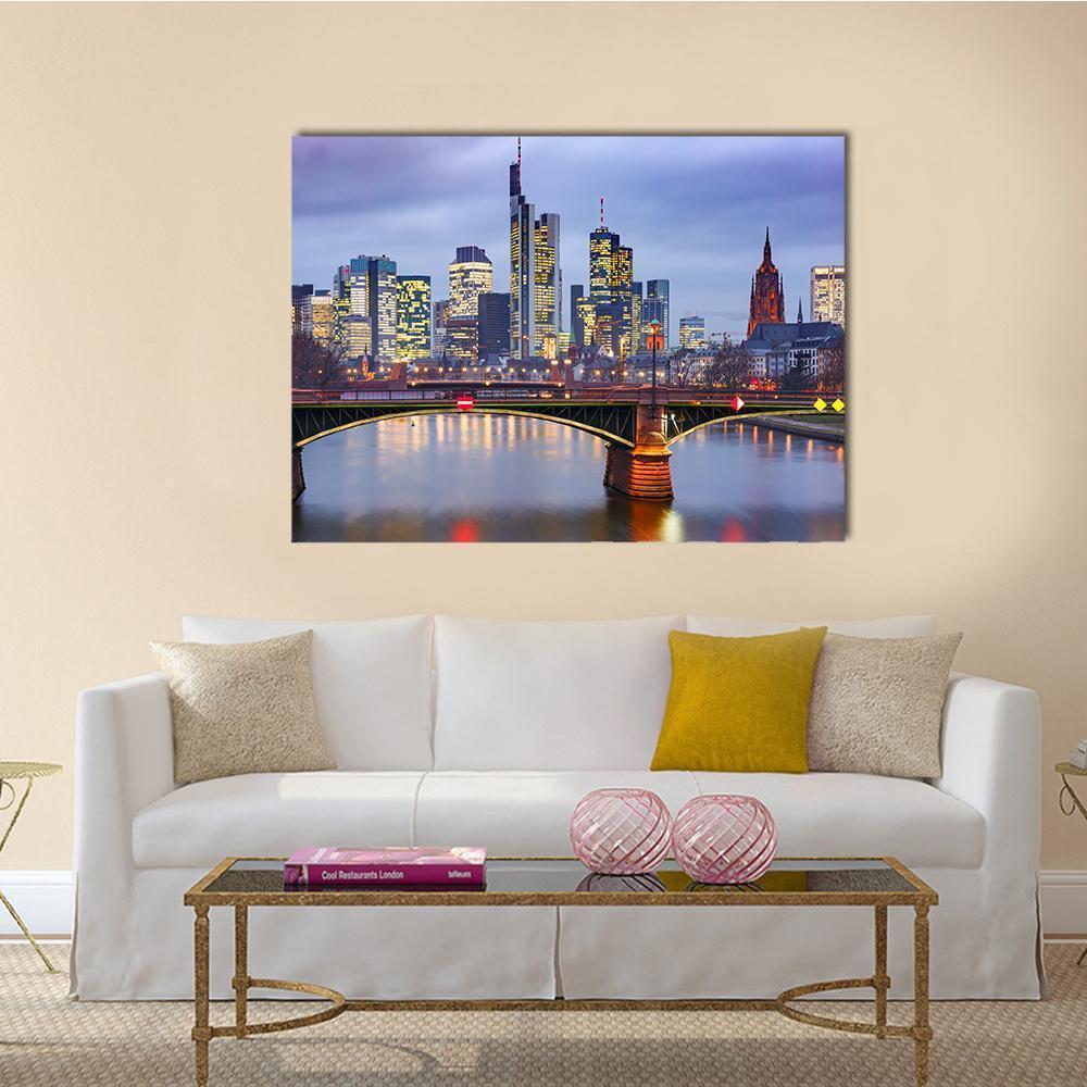 Frankfurt Skyline with River Reflections Canvas Wall Art in yellow, blue and purple, single panel hung on a wall