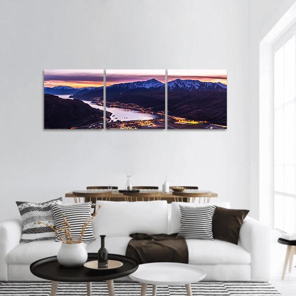 Lake with Snow-capped Mountains at Twilight Panoramic Canvas Wall Art in orange, blue and purple, hung on a wall