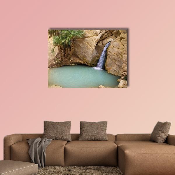 Mountain Oasis Waterfall with Clear Blue Pool Canvas Wall Art in beige, green and blue, single panel hung on a wall