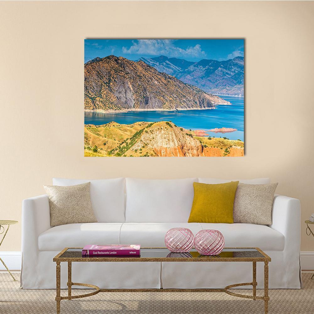 Turquoise Lake Among Rugged Mountain Peaks Canvas Wall Art in brown, yellow and blue, single panel hung on a wall