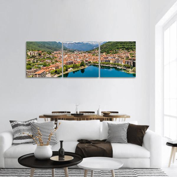 Aerial View of Italian Lakeside Town Panoramic Canvas Wall Art in orange, green and blue, hung on a wall