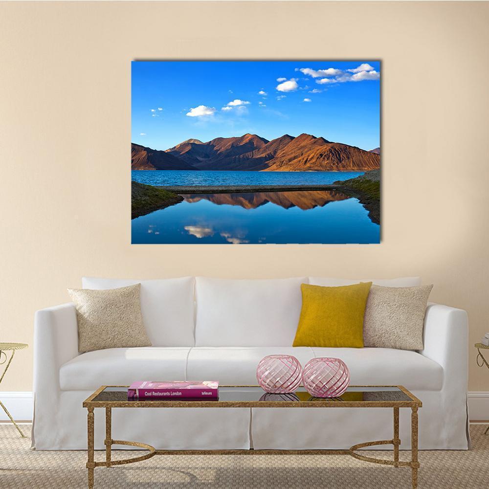 View of Pangong Lake Canvas Wall Art in brown and blue, single panel hung on a wall