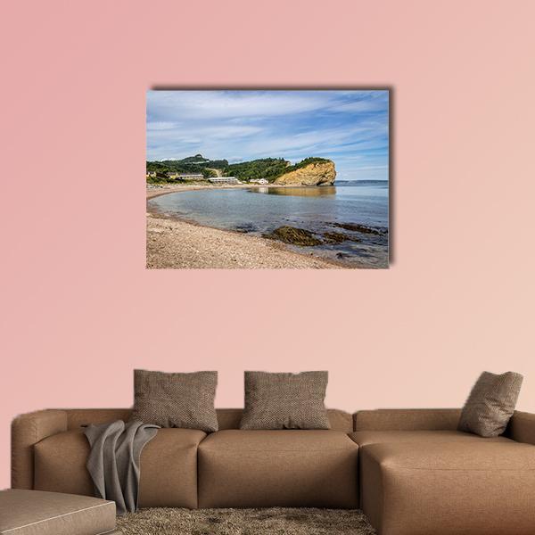 Perce Village Coastal Cliffs and Pebble Beach Canvas Wall Art in beige, brown and blue, single panel hung on a wall