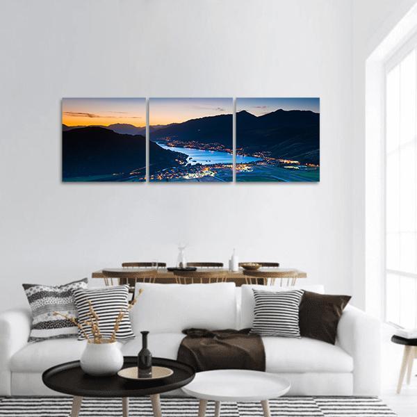 Queenstown Twilight with Lake and City Lights Panoramic Canvas Wall Art in black, orange and blue, hung on a wall