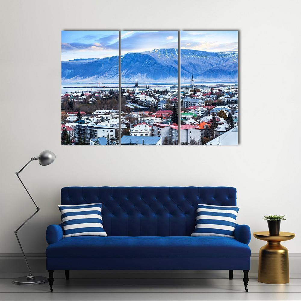 Reykjavik Cityscape with Snow-capped Mountains Canvas Wall Art in white, gray and blue, 3 panel horizontal set hung on a wall