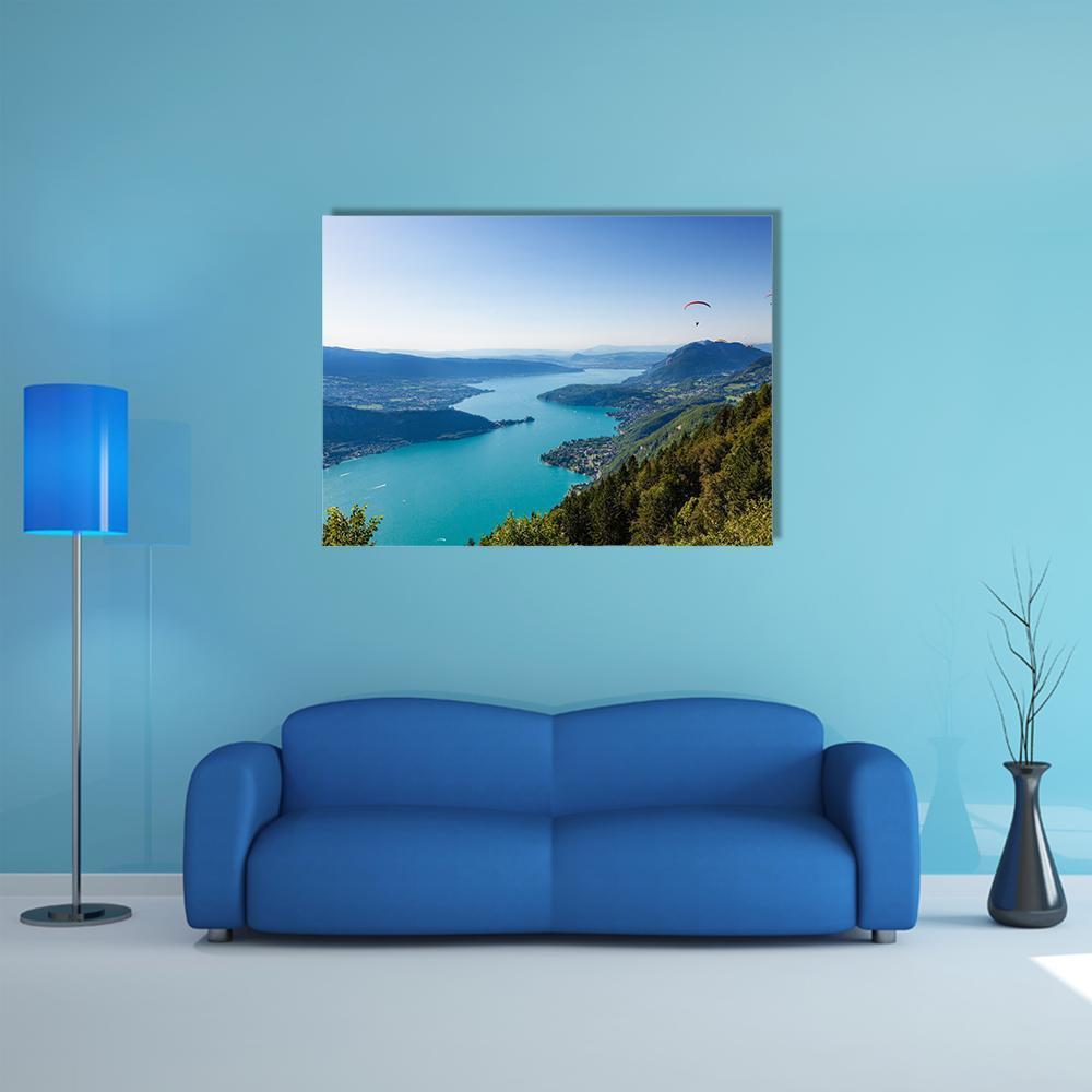 Annecy Lake with Mountains, Town and Paraglider Canvas Wall Art in green and blue, single panel hung on a wall
