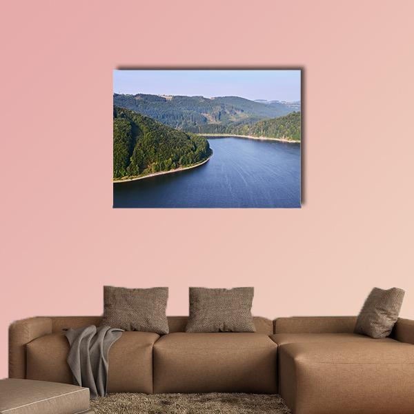 Curving Forested Hills and Blue Lake Canvas Wall Art in green and blue, single panel hung on a wall
