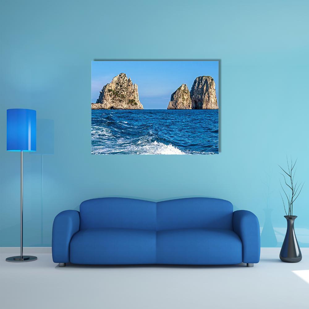 Faraglioni Rock Formations Over Ocean Canvas Wall Art in gray and blue, single panel hung on a wall