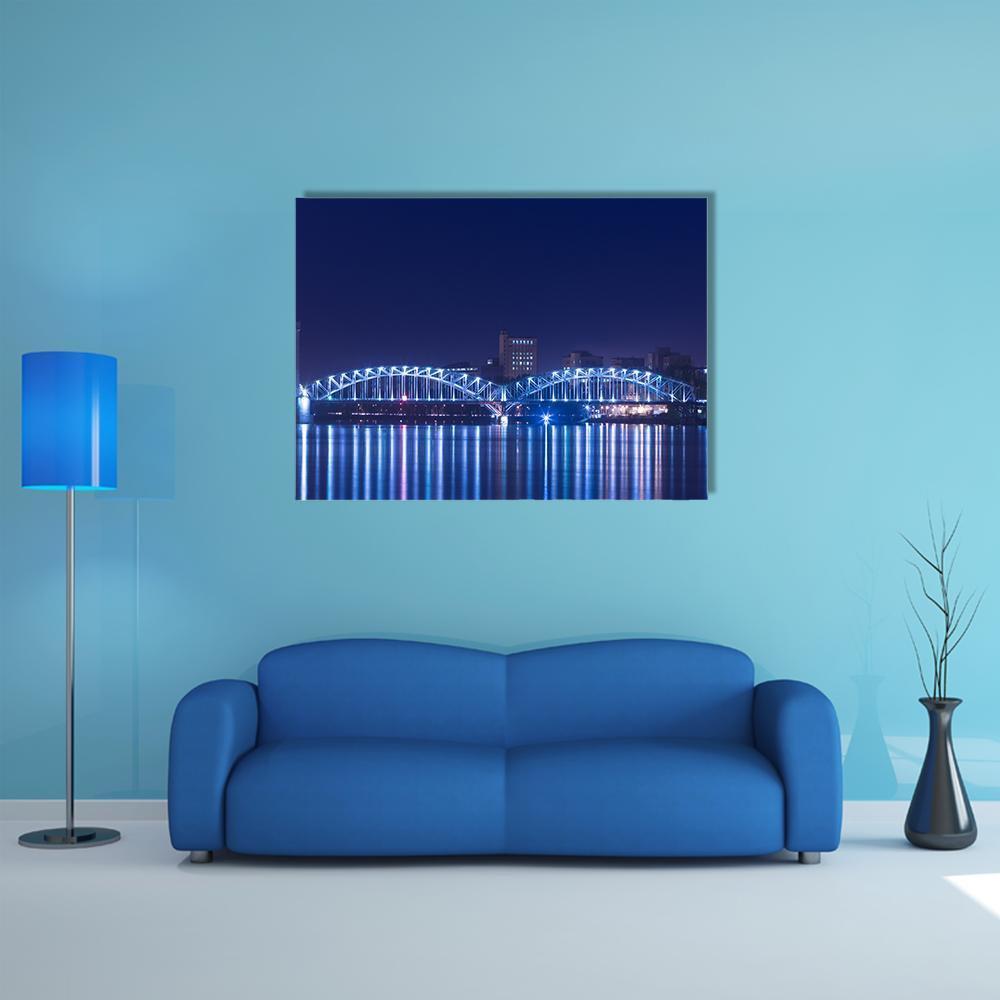 Illuminated Railway Bridge Reflection Canvas Wall Art in blue and navy, single panel hung on a wall