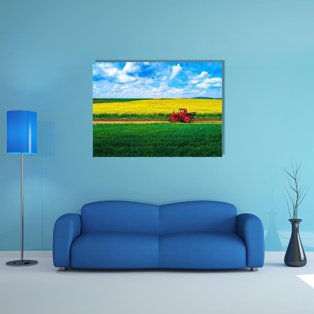 Red Tractor Over Yellow Flower Fields Canvas Wall Art in yellow, green and blue, single panel hung on a wall
