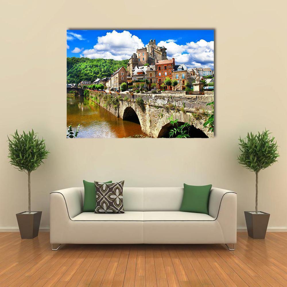 French Hilltop Village with Stone Bridge Canvas Wall Art in brown, green and blue, single panel hung on a wall