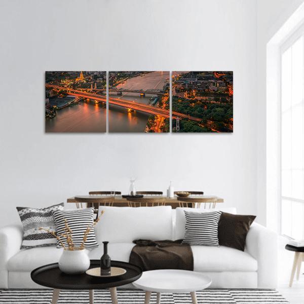Vintage Bridge with Glowing Streetlights Panoramic Canvas Wall Art in black, brown and orange, hung on a wall