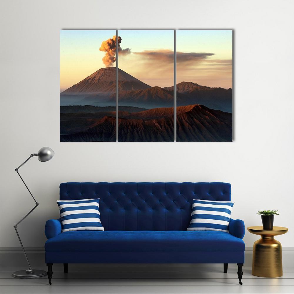Semeru Volcano Erupting Canvas Wall Art in brown, orange and blue, 3 panel horizontal set hung on a wall