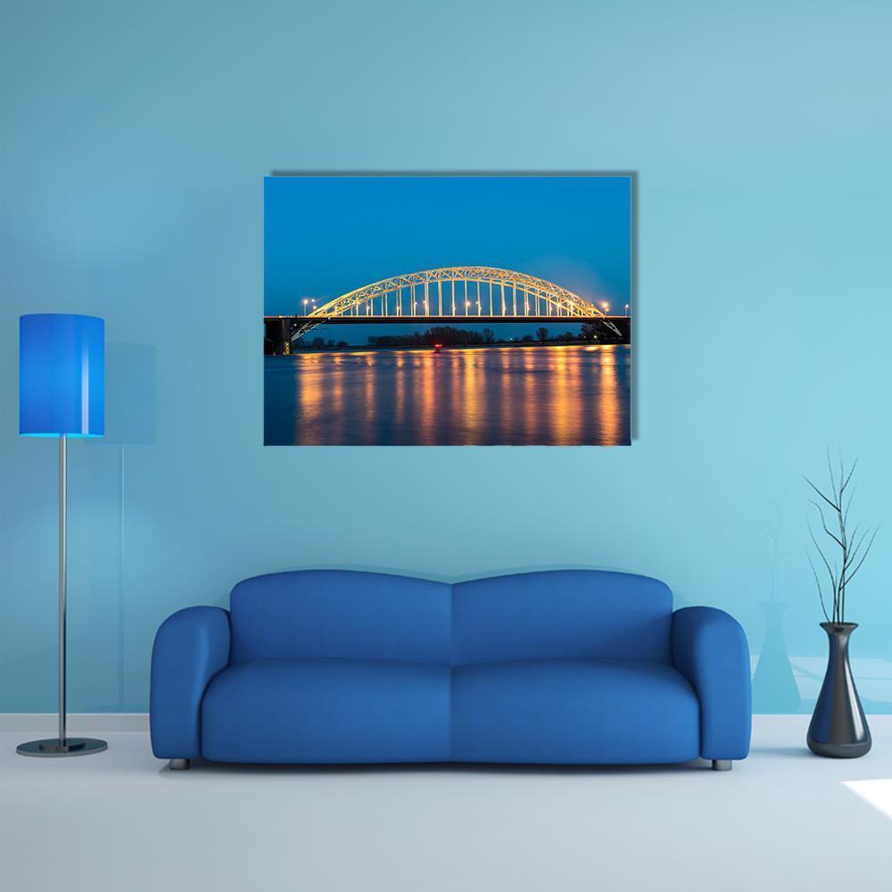 Waal Bridge at Nijmegen Night View Canvas Wall Art in orange, yellow and blue, single panel hung on a wall