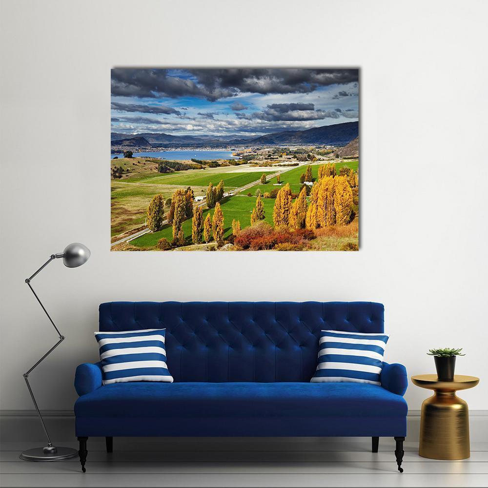 Lake Wanaka Autumn Landscape Canvas Wall Art in yellow, green and blue, single panel hung on a wall