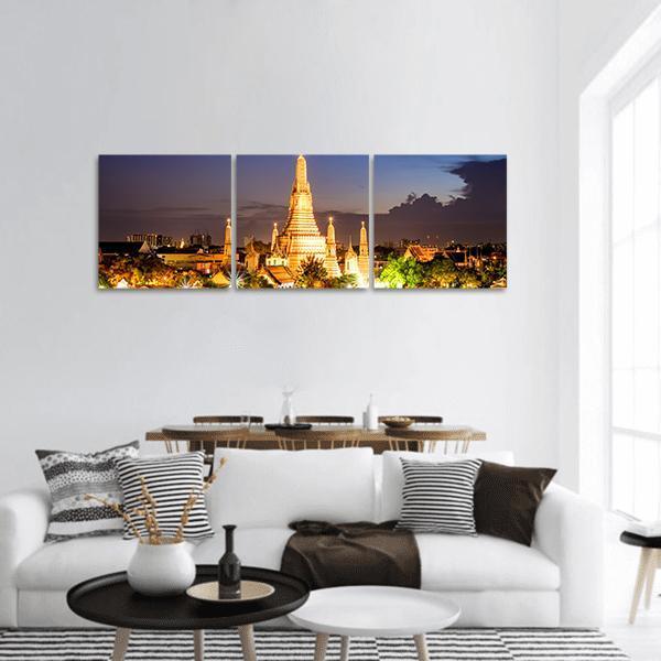 Wat Arun Temple at Night Panoramic Canvas Wall Art in gold, yellow and blue, hung on a wall