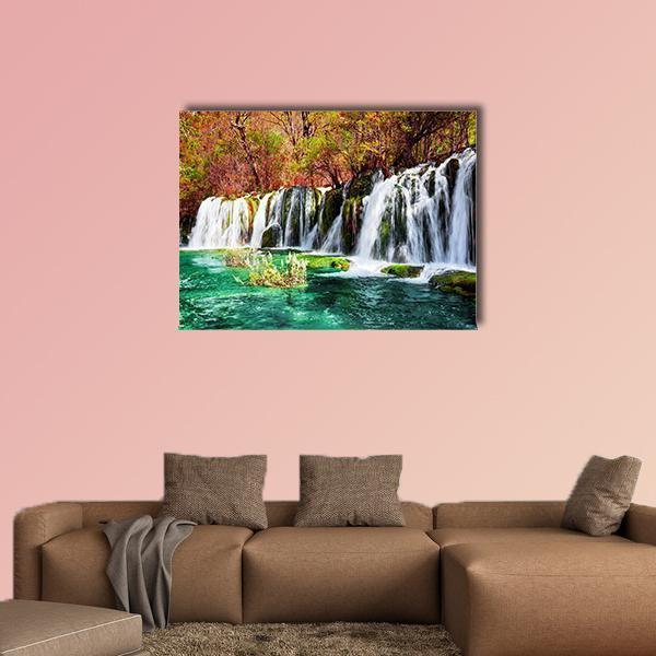 Turquoise Lake with Cascading Waterfall Canvas Wall Art in white, green and blue, single panel hung on a wall