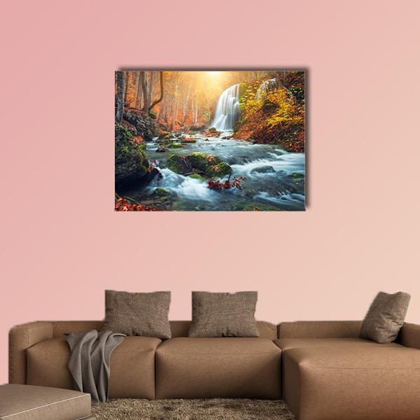 Mountain River Waterfall in Autumn Forest Canvas Wall Art in brown, orange and yellow, single panel hung on a wall