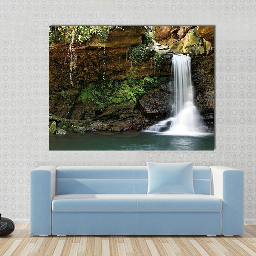 Silky Waterfall Over Mossy Rocks Canvas Wall Art in white, brown and green, single panel hung on a wall