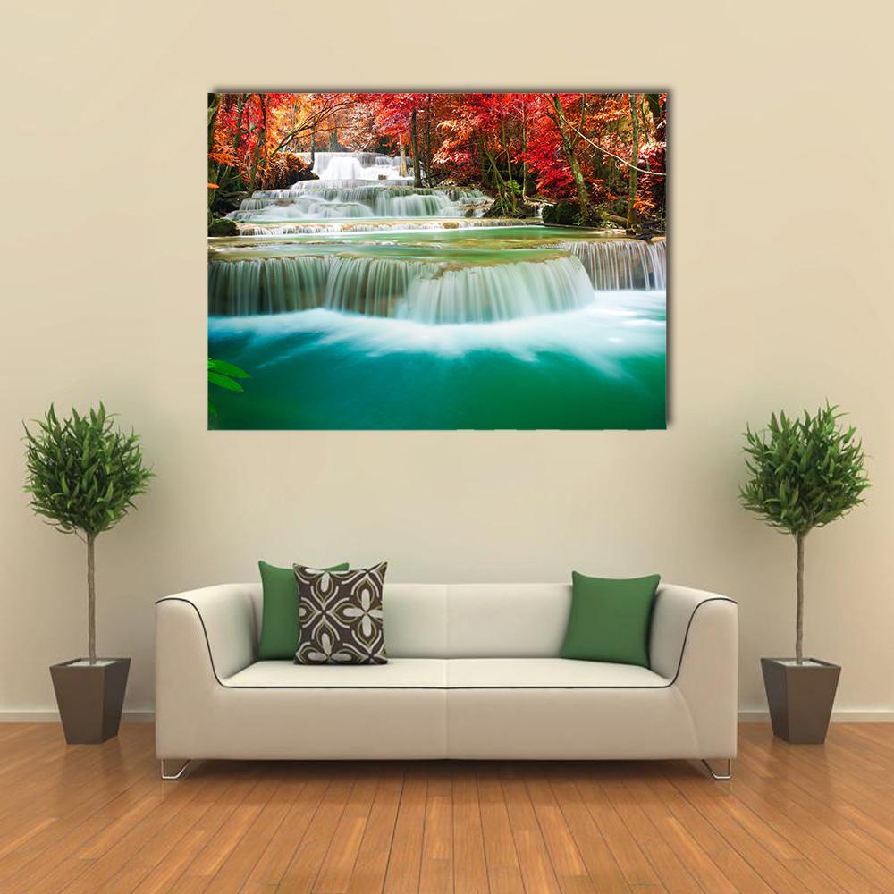 Autumn Forest Waterfall with Turquoise Pool Canvas Wall Art in red, orange and green, single panel hung on a wall