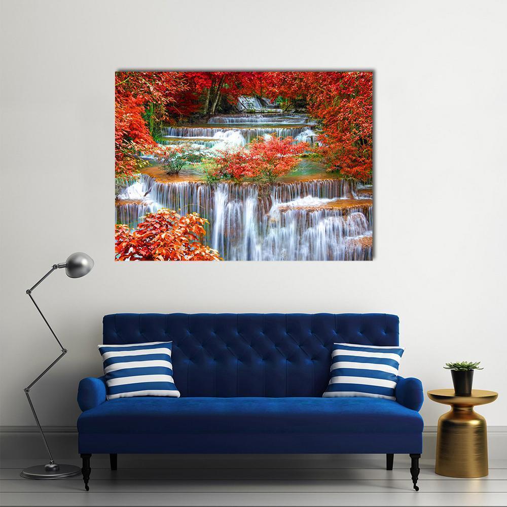 Autumn Waterfall in Deep Rainforest Canvas Wall Art in red, orange and green, single panel hung on a wall