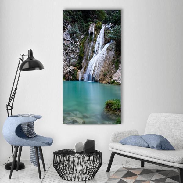 Long-exposure Forest Waterfall Vertical Canvas Wall Art in gray, green and blue, single vertical panel hung on a wall