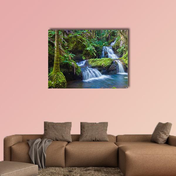 Tropical Rainforest Waterfall Canvas Wall Art in brown, green and blue, single panel hung on a wall