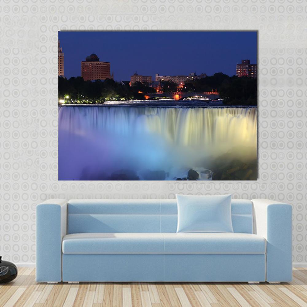 Waterfall with City Lights at Night Canvas Wall Art in blue, navy and purple, single panel hung on a wall