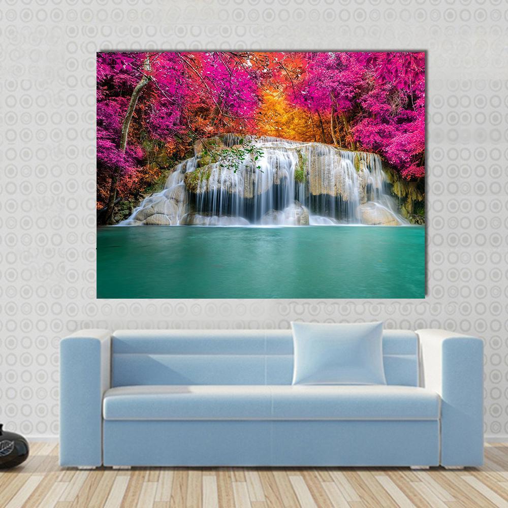 Waterfall with Pink Trees Canvas Wall Art in orange, green and pink, single panel hung on a wall